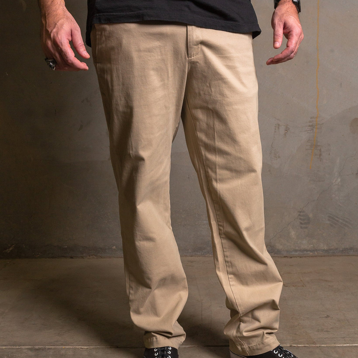 Dixxon Canada. Khaki Chino Pants. Model wearing slim-fit, straight-leg chino pants with a clean front design and dual front slash pockets.